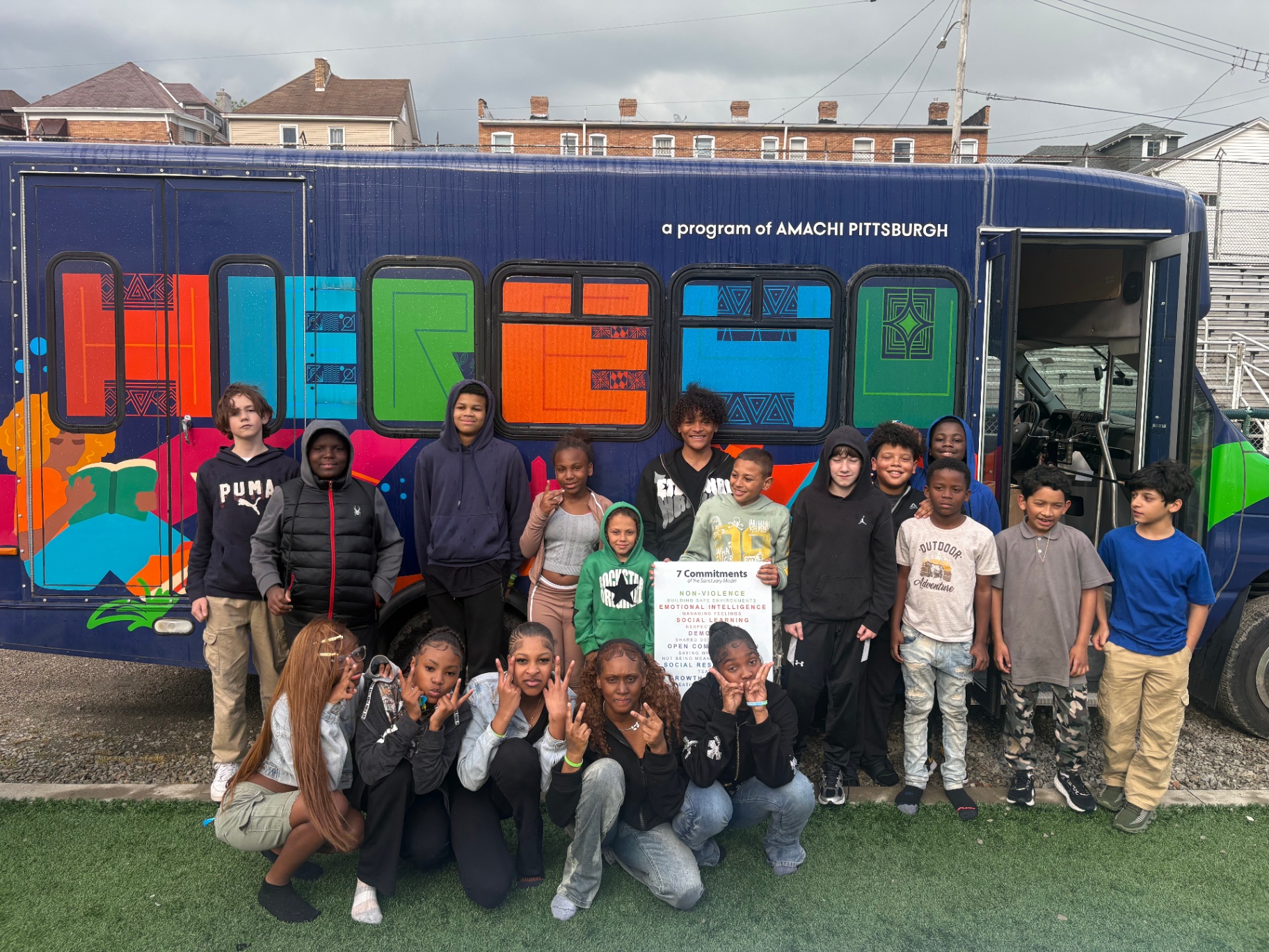 Amachi Pittsburgh youth gathered in front of the HERE4U mobile unit bus.